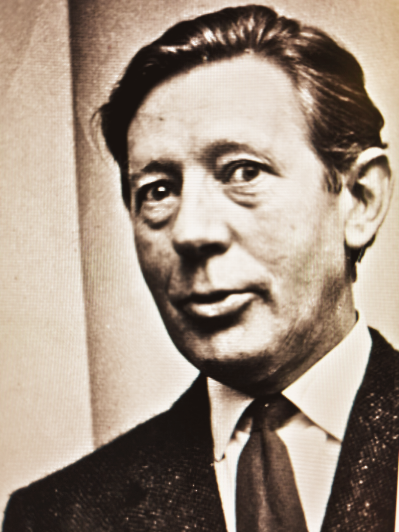 Laurie Lee the author wearing a tweed suit and tie with slicked back hair