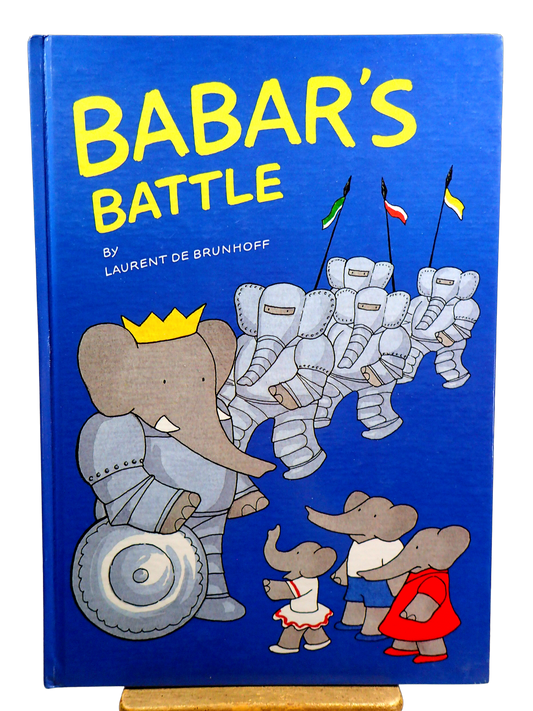 Babar the Elephant in a suit of Armour wearing a crown with other  elephants on Front cover of Babar's Battle First Edition Children's book