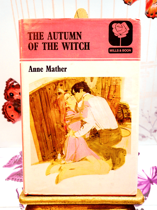 Pink front cover showing a man embracing a woman of Autumn of the Witch First Edition vintage hardback Mills and Boon Book.