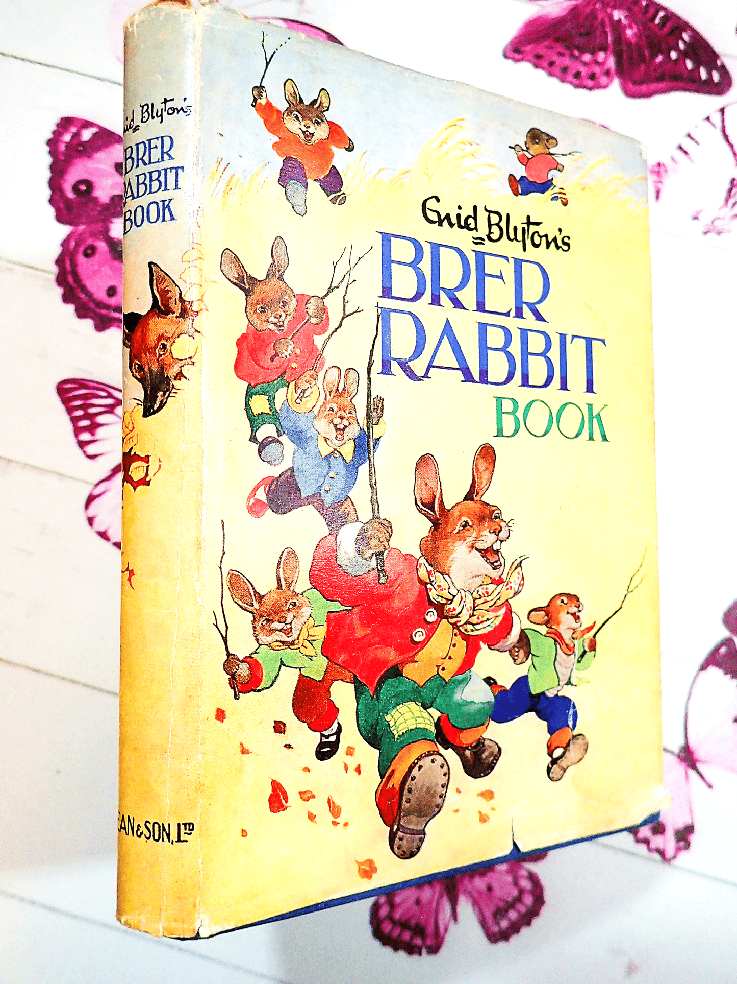 Front Cover and Spine of Enid Blyton's Brer Rabbit Book Vintage Childrens Bedtime Stories First Edition 1963 showing lots of dressed Bunnies running in a hay field and Brer Wolf on the spine.