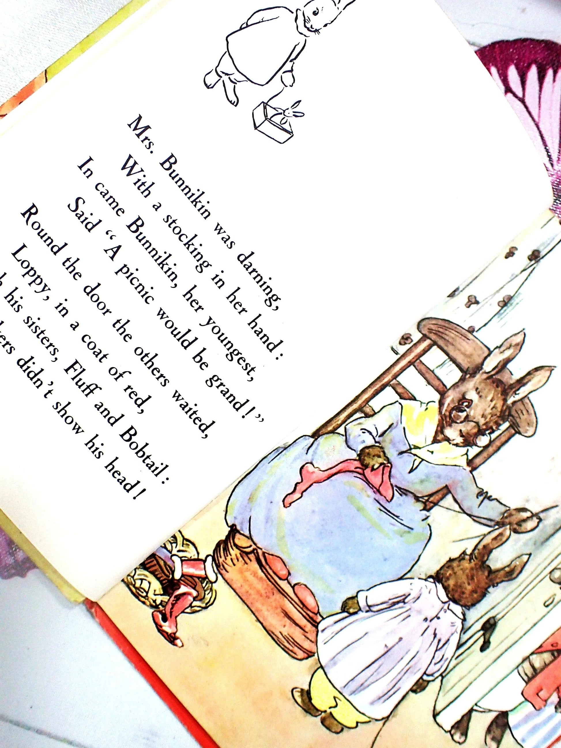 Mrs Bunnikin darning with a stocking in her hand.