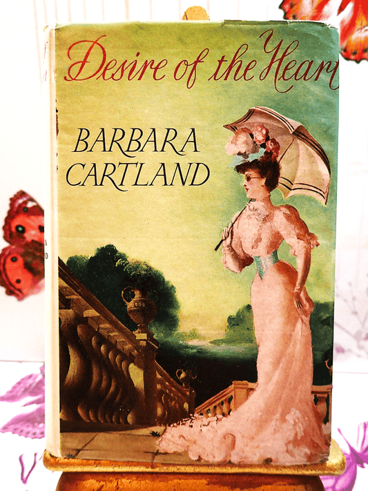 Front cover of Desire of the Heart Barbara Cartland Hardback showing a lady dressed in pink holding a pasrasol.