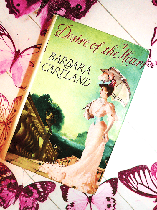 Front cover of Desire of the Heart Barbara Cartland Hardback showing a lady dressed in pink holding a pasrasol.