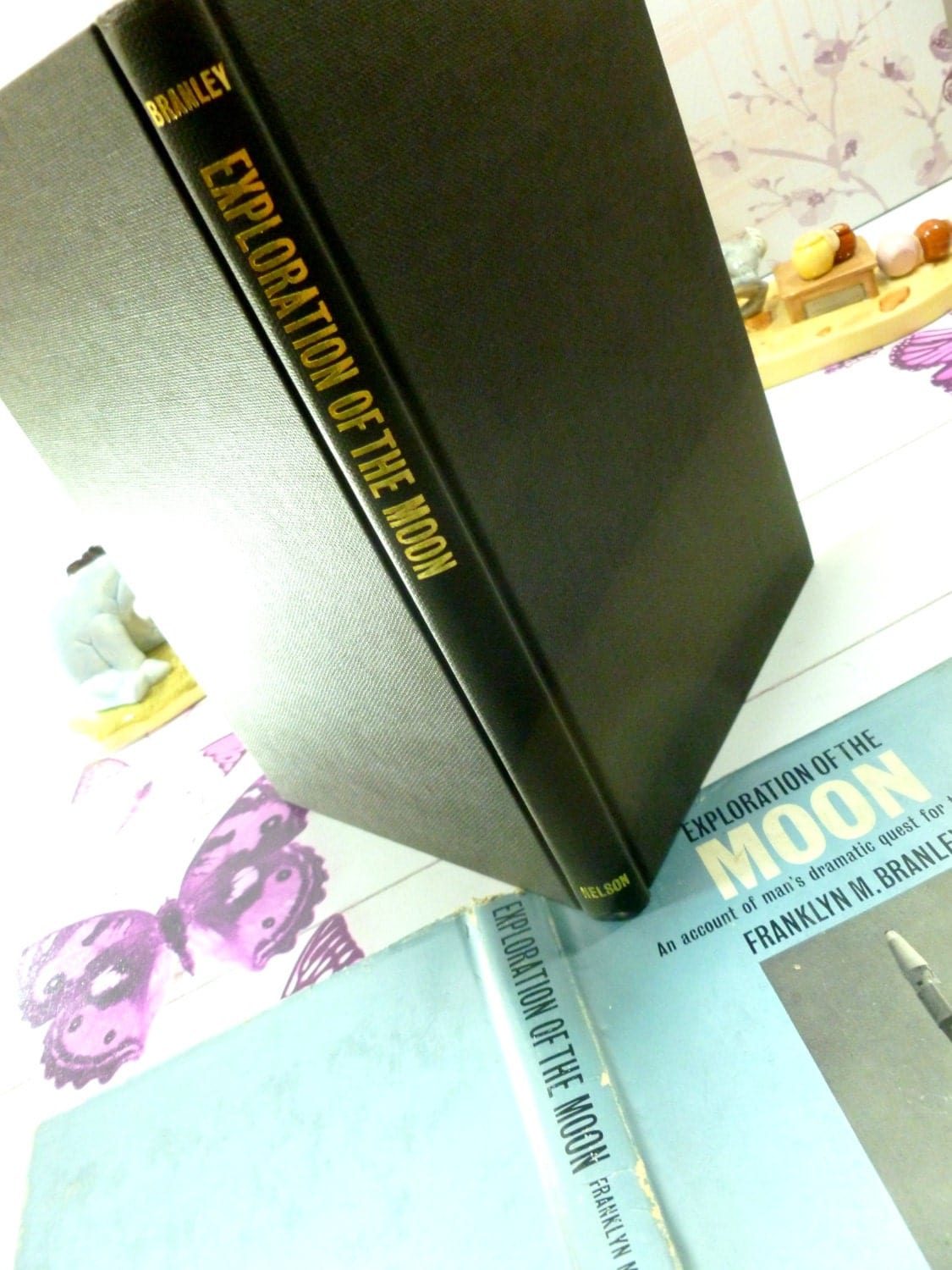 Black cloth bound boards of vintage book Exploration of the Moon with gilt titles to the spine.