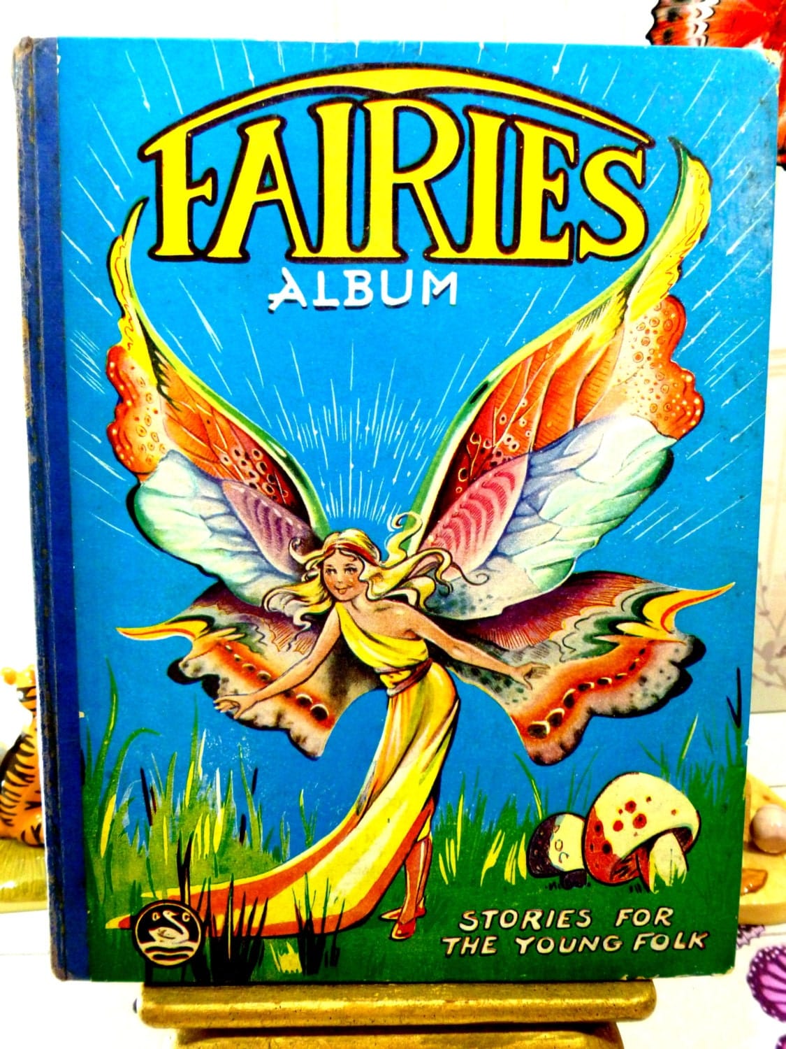 Cover of Vintage Fairy Story Book 1957 Fairies Album Stories for The Young Folk by Gerald G. Swan with fairy flapping beautiful rainbow coloured wings.