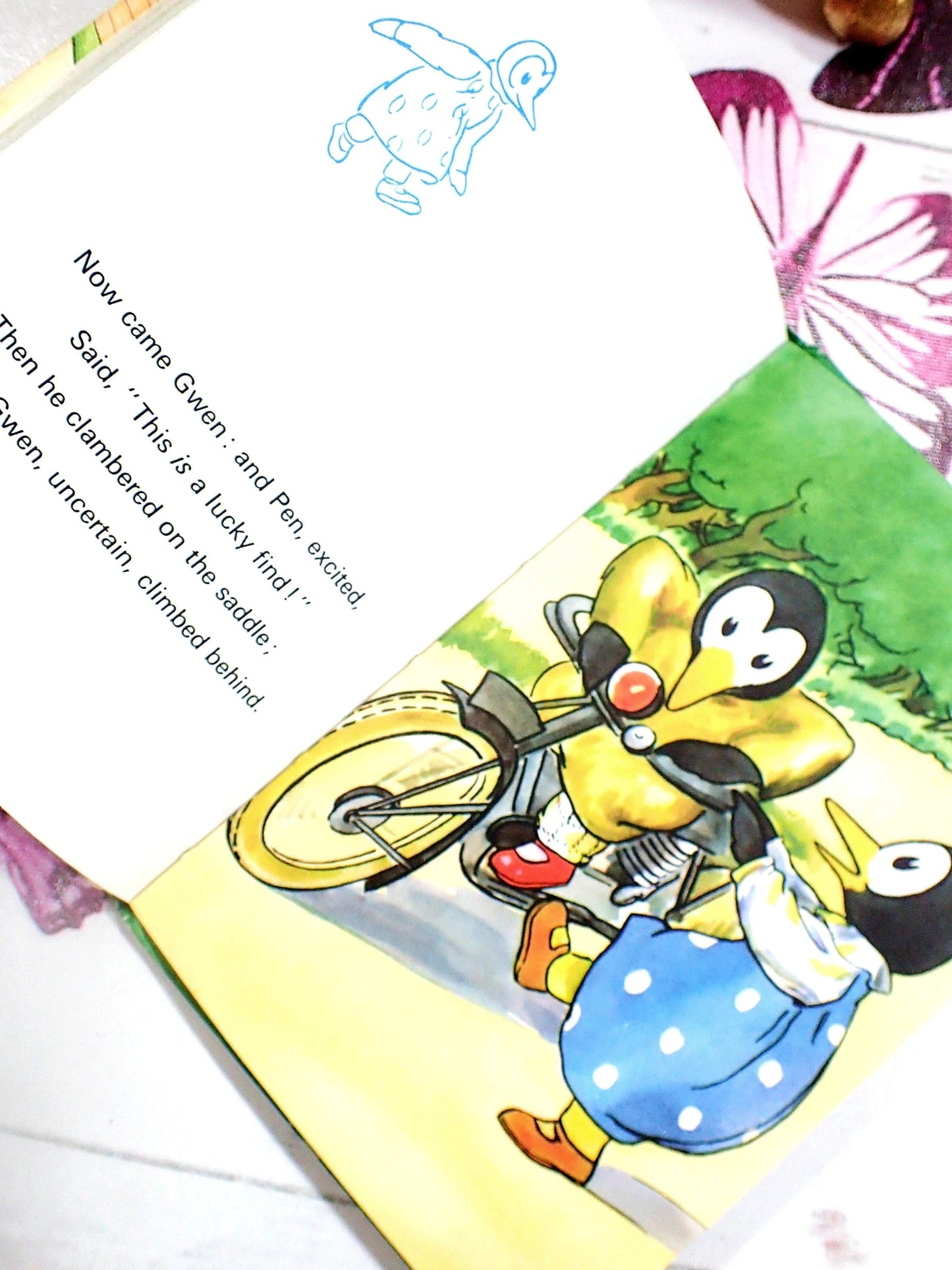 Two penguin children getting on a motorcycle.