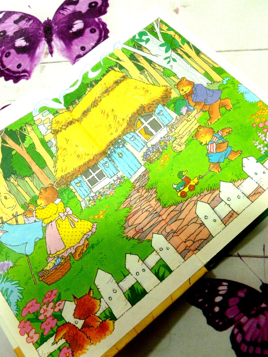 Decorated endpapers in vintage Ladybird book showing the bear family outside their cottage in the woods. Goldilocks and the Three Bears. Well Loved Tales.