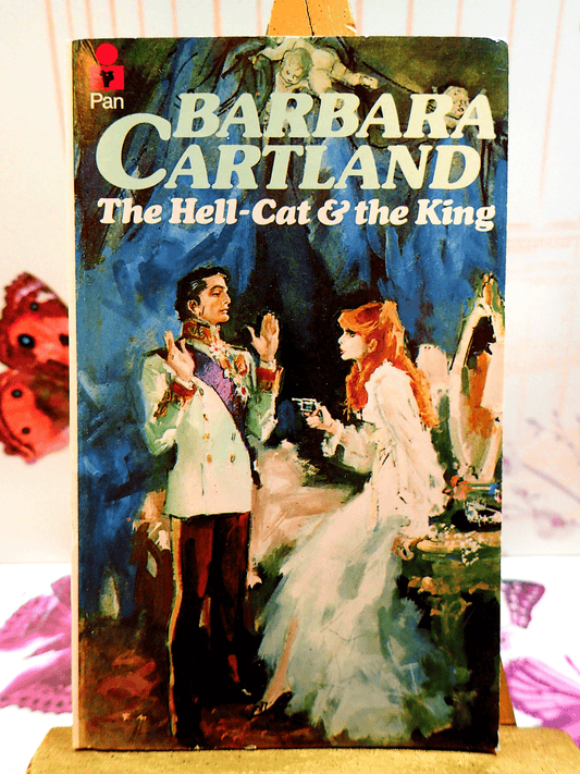 Cover of The Hell Cat and the King Barbara Cartland Pan Paperback First Edition showing a red haired woman pointing a gun at a handsome aristocrat. 