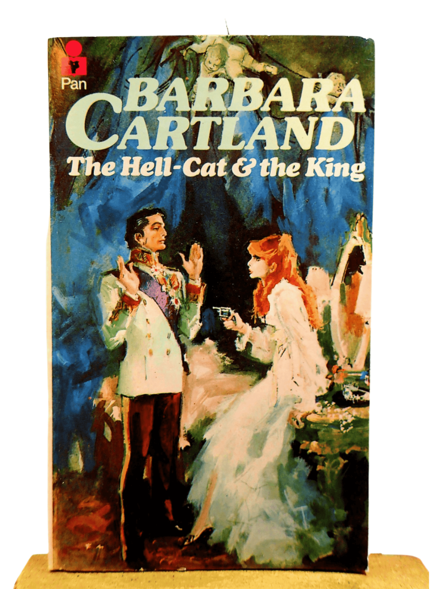 Cover of The Hell Cat and the King Barbara Cartland Pan Paperback First Edition showing a red haired woman pointing a gun at a handsome aristocrat.