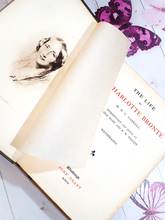 Pages of antique book The Life of Charlotte Bronte by Mrs Gaskell 1907 showing a sepia portrait of Charlotte Bronte with Tissue guard and titles.