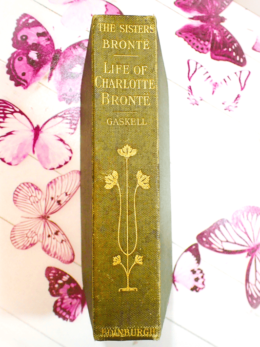 Spine of antique book  The Life of Charlotte Bronte by Mrs Gaskell 1907 with decorative gilt titles on sage green cloth boards. 