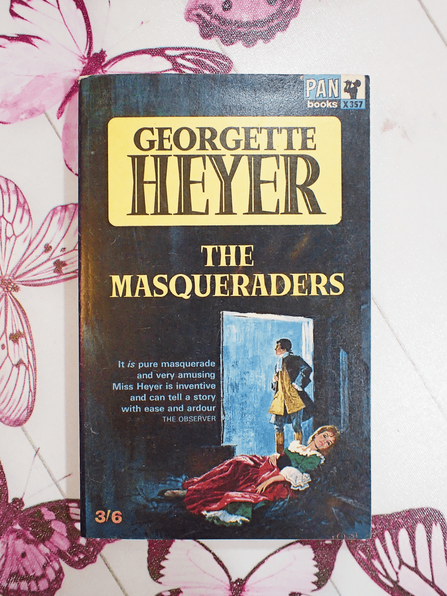 Front cover of vintage Pan paperback book, 'The Masqueraders', by Georgette Heyer showing a man and woman in Georgian costume and the book titles in yellow and black.