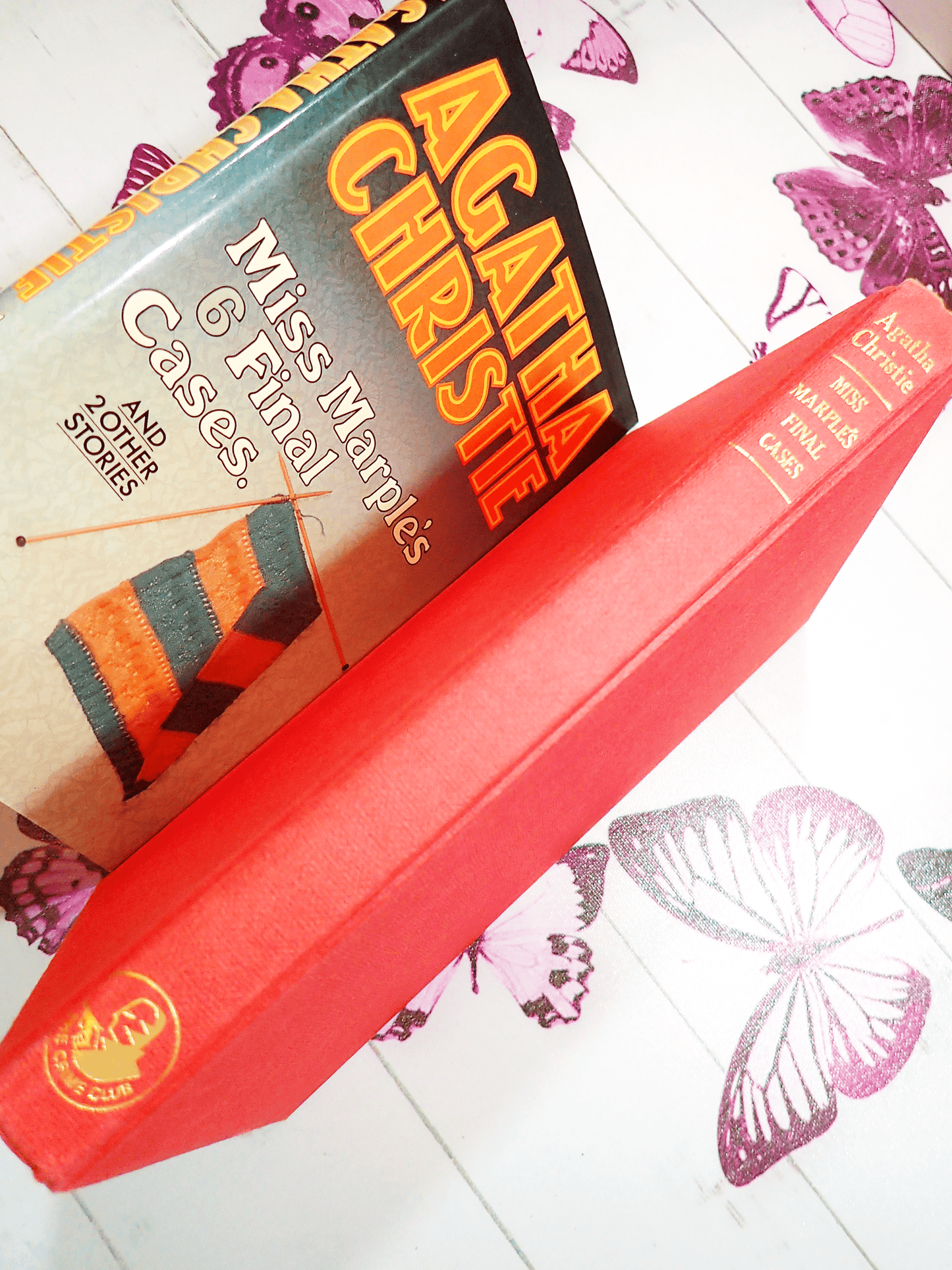 Red boards of Agatha Christie Miss Marples Final Cases Collins Crime Club First Edition Book 1979 showing gold titles and Crime Club Logo with Dust Jacket behind.