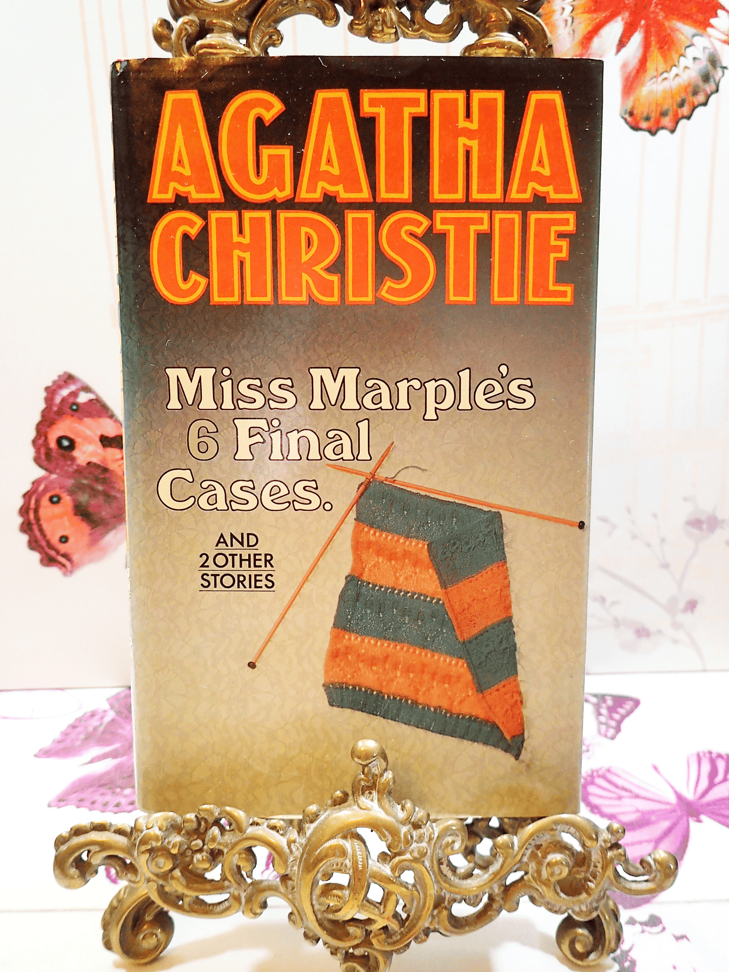 Front cover of Agatha Christie Miss Marples Final Cases Collins Crime Club First Edition Book 1979 showing some stripey knitting and titles in orange.