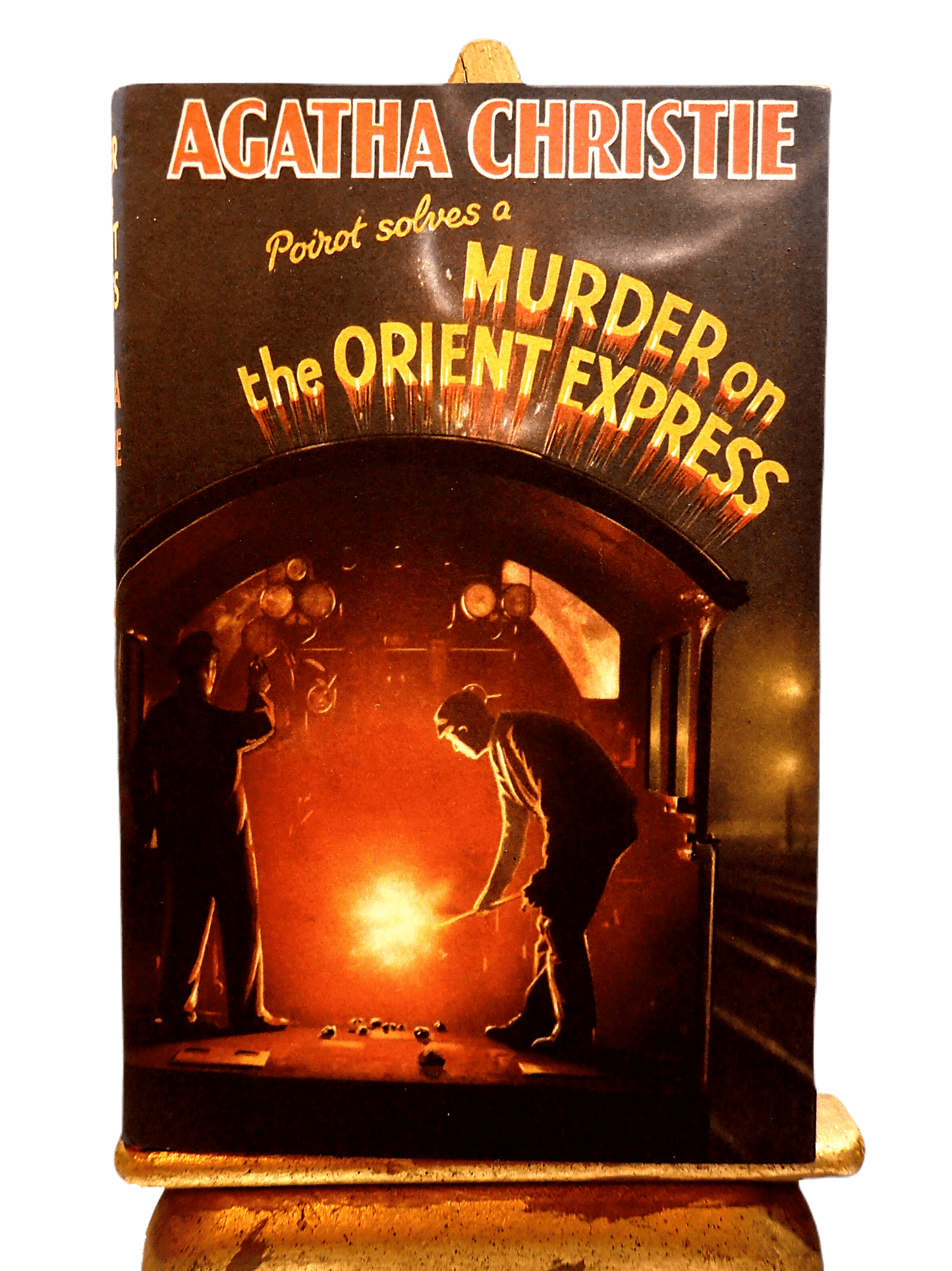 Front cover of Murder on the Orient Express Agatha Christie Facsimile Vintage Book showing a man shovelling coal into a train furnace.