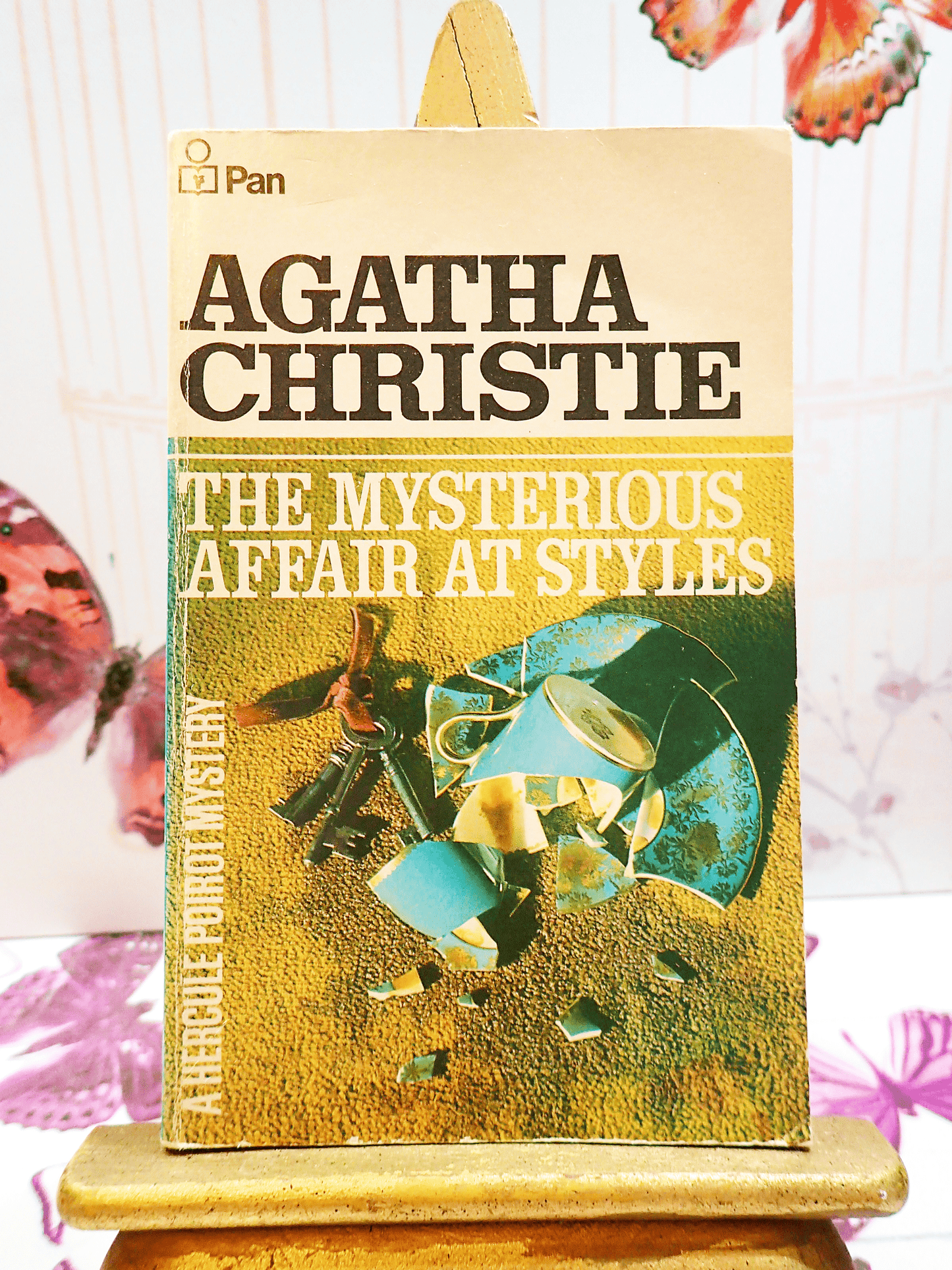 Front cover of Agatha Christie's book The Mysterious Affair at Style, Vintage Pan Paperback, showing a broken coffee cup on the carpet next to a bunch of keys.