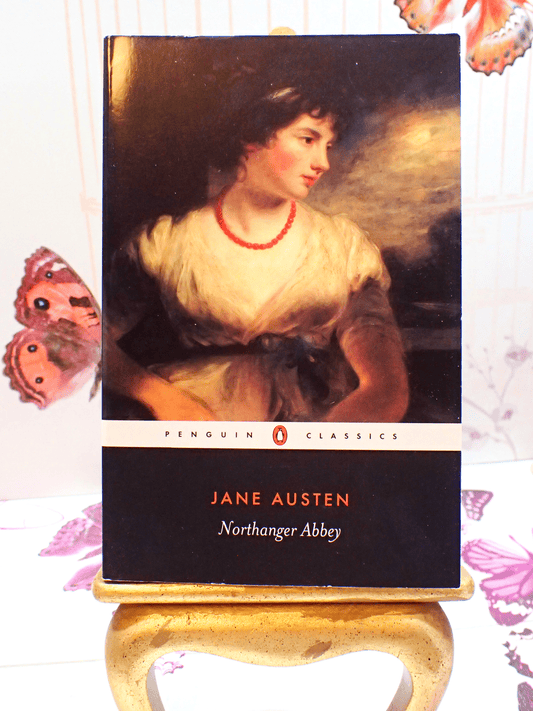 Front cover of Northanger Abbey Jane Austen Puffin Paperback showing a Regency lady wearing a coral necklace against a butterfly background. 