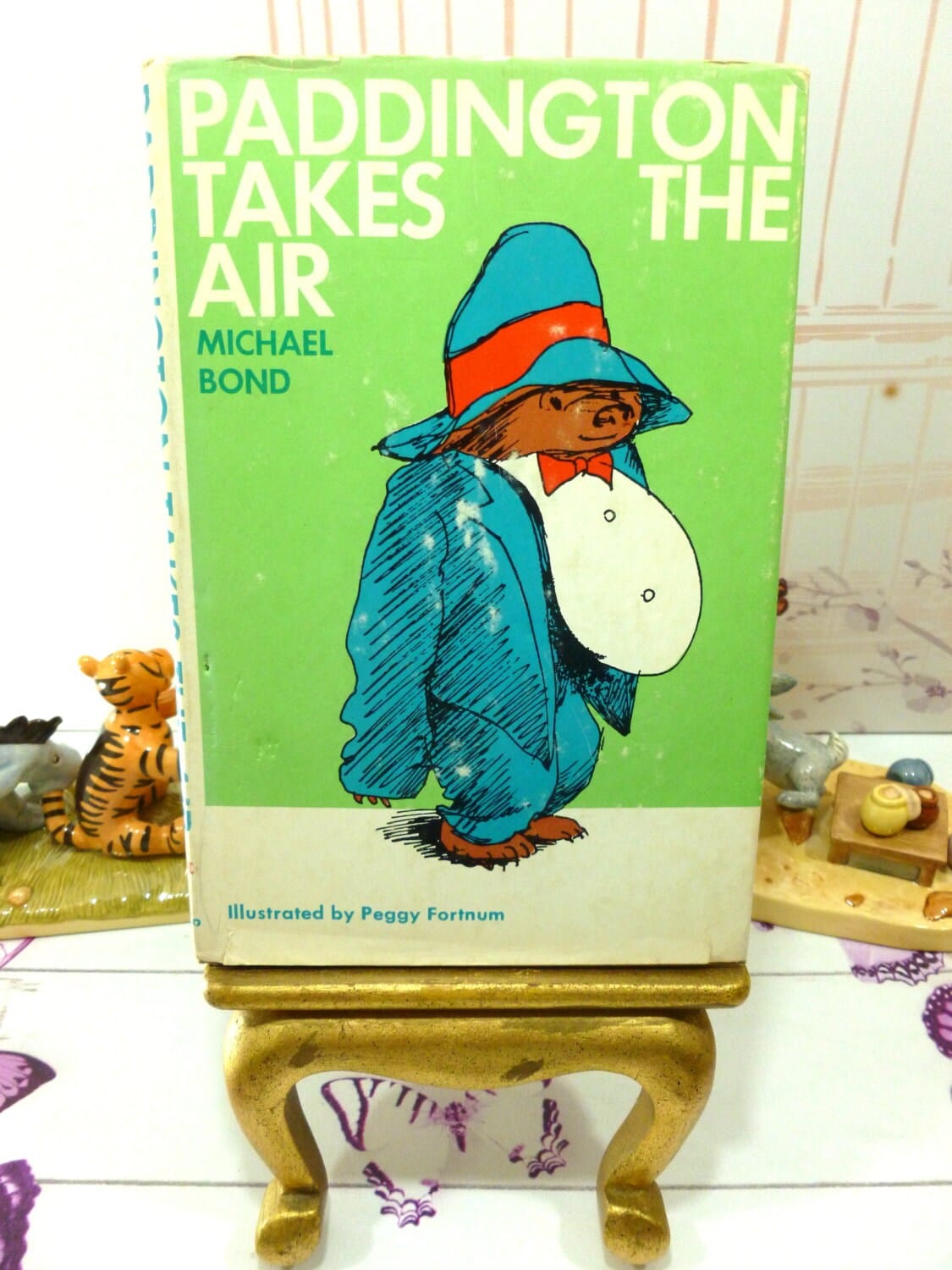 Front cover of Paddington Takes the Air Vintage Book First American Edition with Dust Jacket showing Paddington Bear in Tuxedo against a green ground.