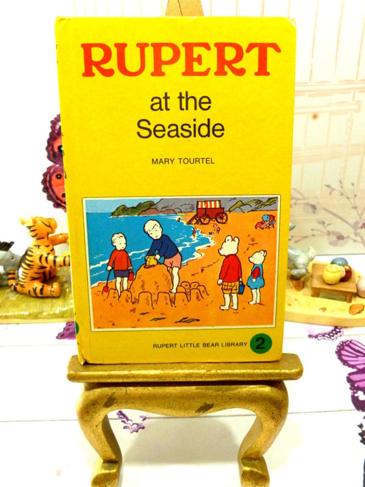 Yellow front cover of vintage Rupert the Bear book with Rupert and friends aet the beach.