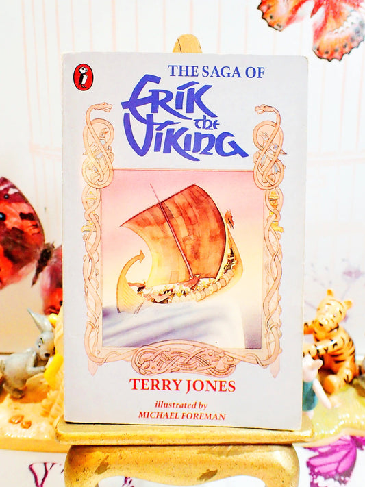 Front cover of The Saga of Erik the Viking by Terry Jones Vintage Puffin Children's Book 1988 showing a Viking Ship sailing against a grey ground with celtic ornamentation. 