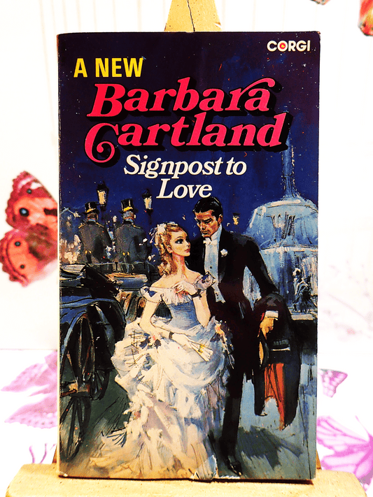 Front cover of Signpost to Love Barbara Cartland Corgi Paperback showing a lady in Victorian dress with a fan next to a handsome gentleman.