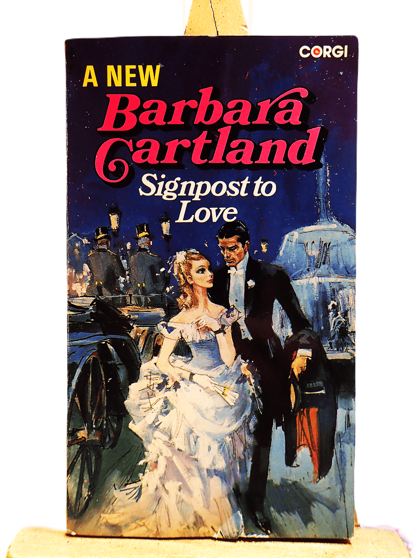 Front cover of Signpost to Love Barbara Cartland Corgi Paperback showing a lady in Victorian dress with a fan next to a handsome gentleman.