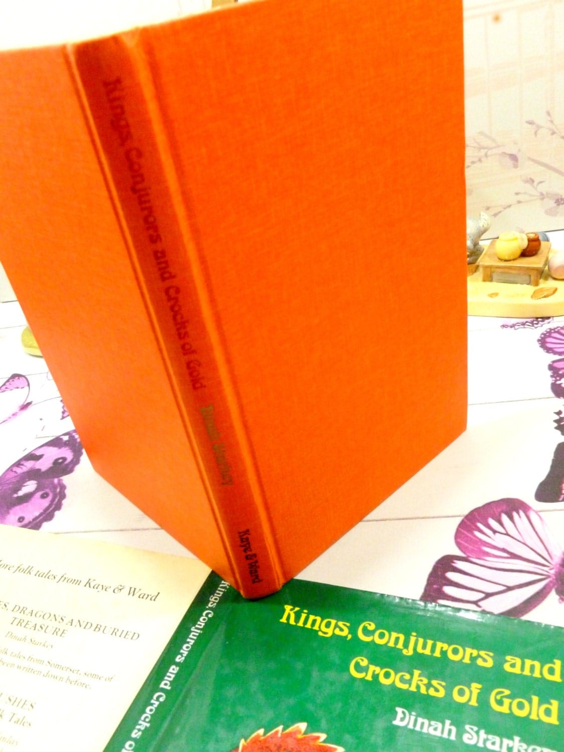 Orange cloth covered boards and spine of Kings Conjurors and Crocks of Gold 1975 folk tale book with gilt titles.