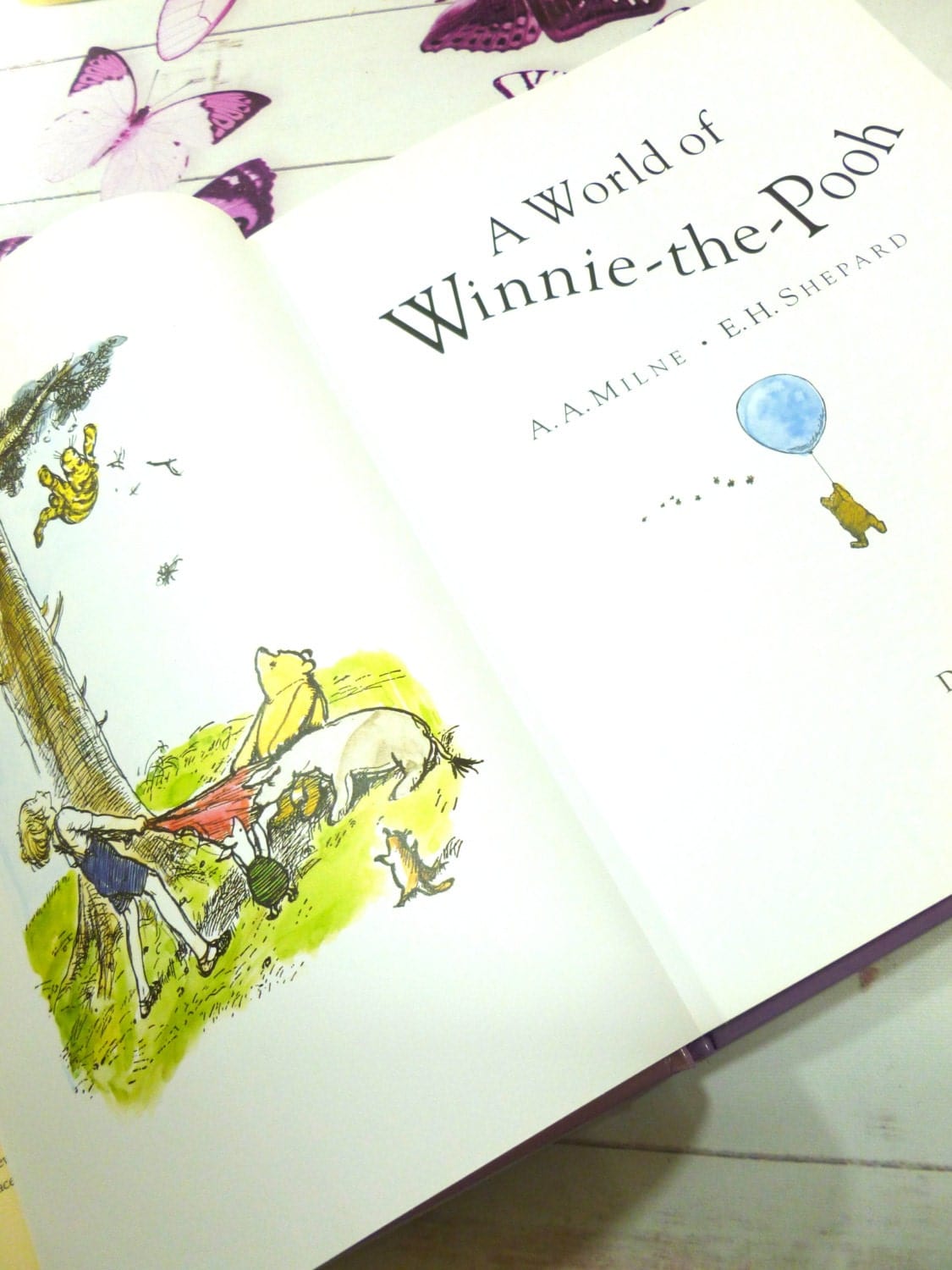 Title page and Frontispiece of Front cover of A World of Winnie the Pooh Vintage Hardback Childrens Book illustrated with images of Christopher Robin, Pooh, Piglet and Roo.