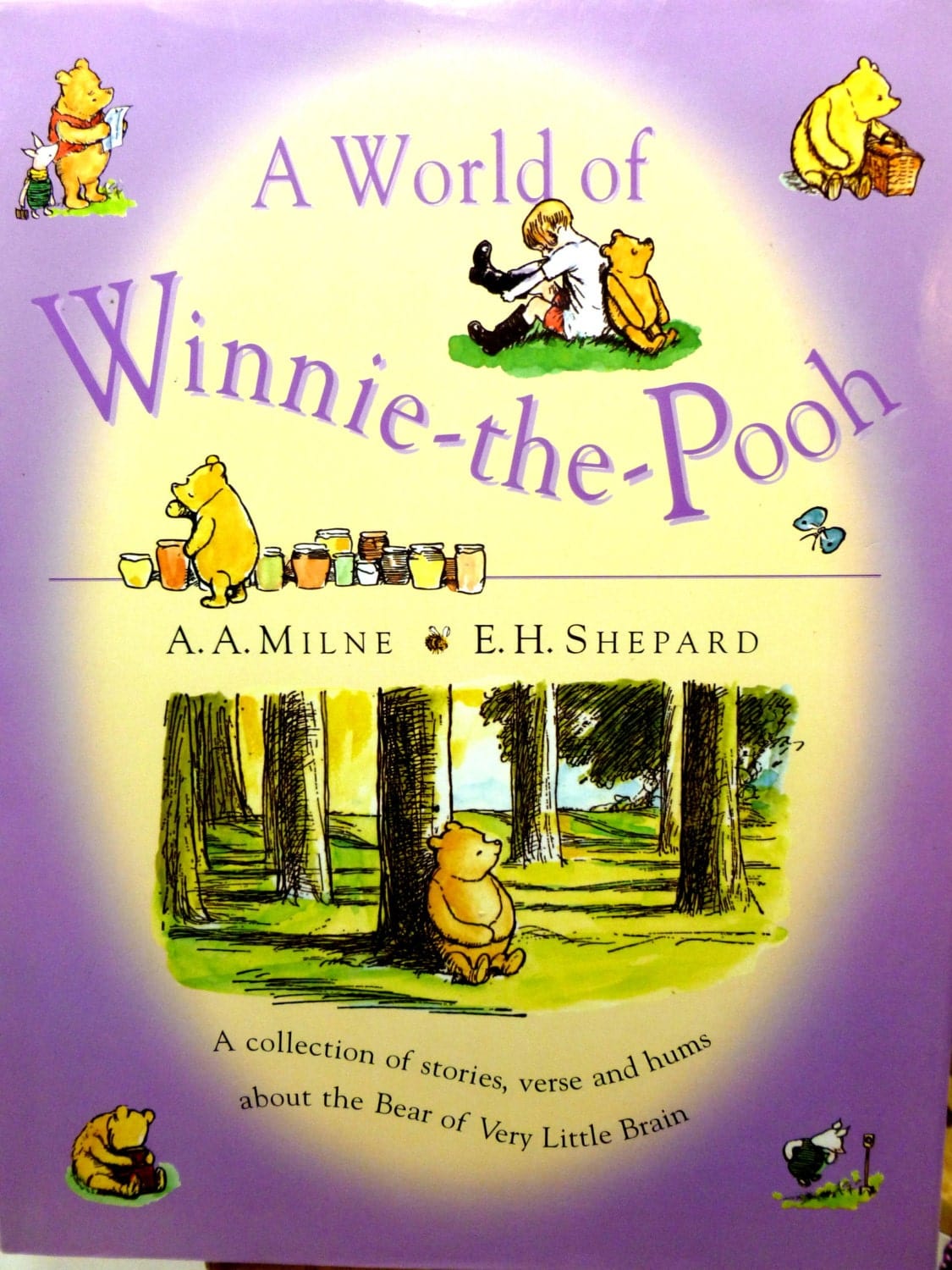 Front cover of A World of Winnie the Pooh Vintage Hardback Childrens Book illustrated with images of Christopher Robin and Pooh against a lilac ground.