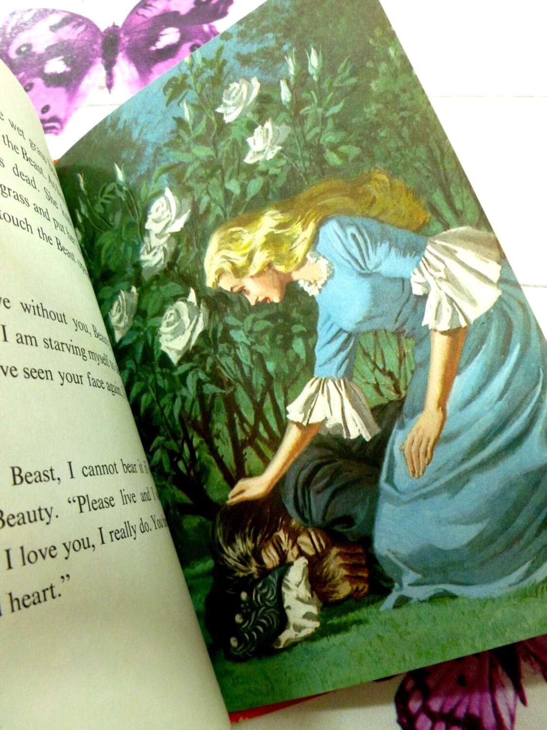 Illustration from Ladybird Vintage Children's book Beauty and the Beast Well-Loved Tales showing a beautiful lady in a blue dress comfortoing the beast.