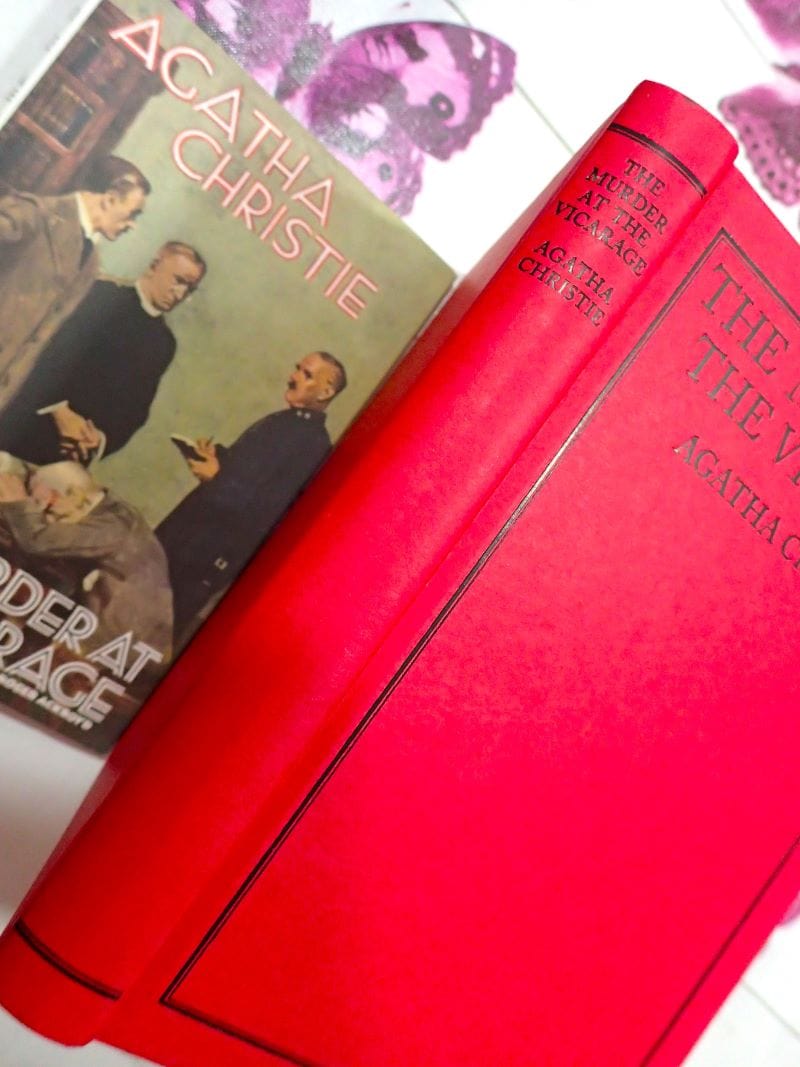 Red binding with black titles on the spine of The Murder at the Vicarage Agatha Christie