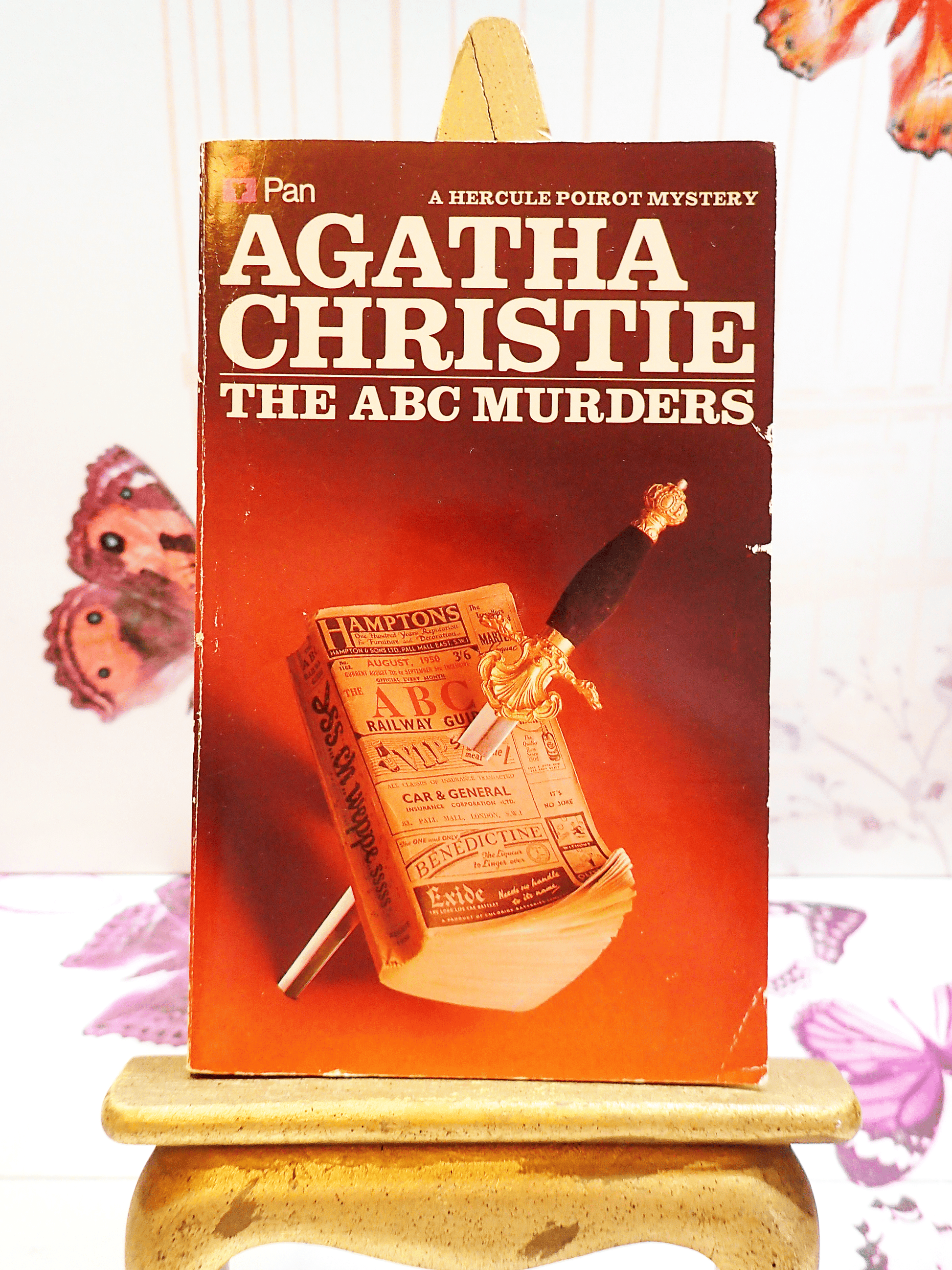 Front Cover of Agatha Christie The ABC Murders, Vintage Pan Paperback Book. Classic Crime Fiction. Showing an ABC Railway guide with a dagger through it against a blood red background. 