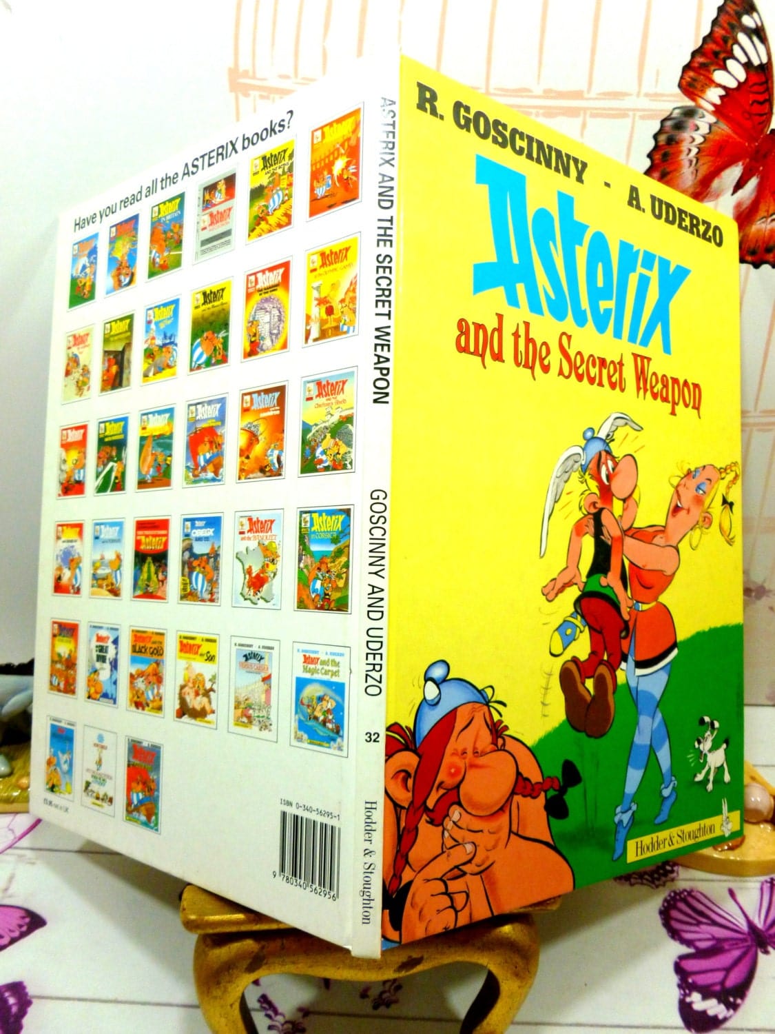 Back and front cover of Asterix and the Secret Weapon Goscinny Uderzo the Gaul series First English Edition 1991 showing Asterix on the front cover and other books available in the series on the back cover. 