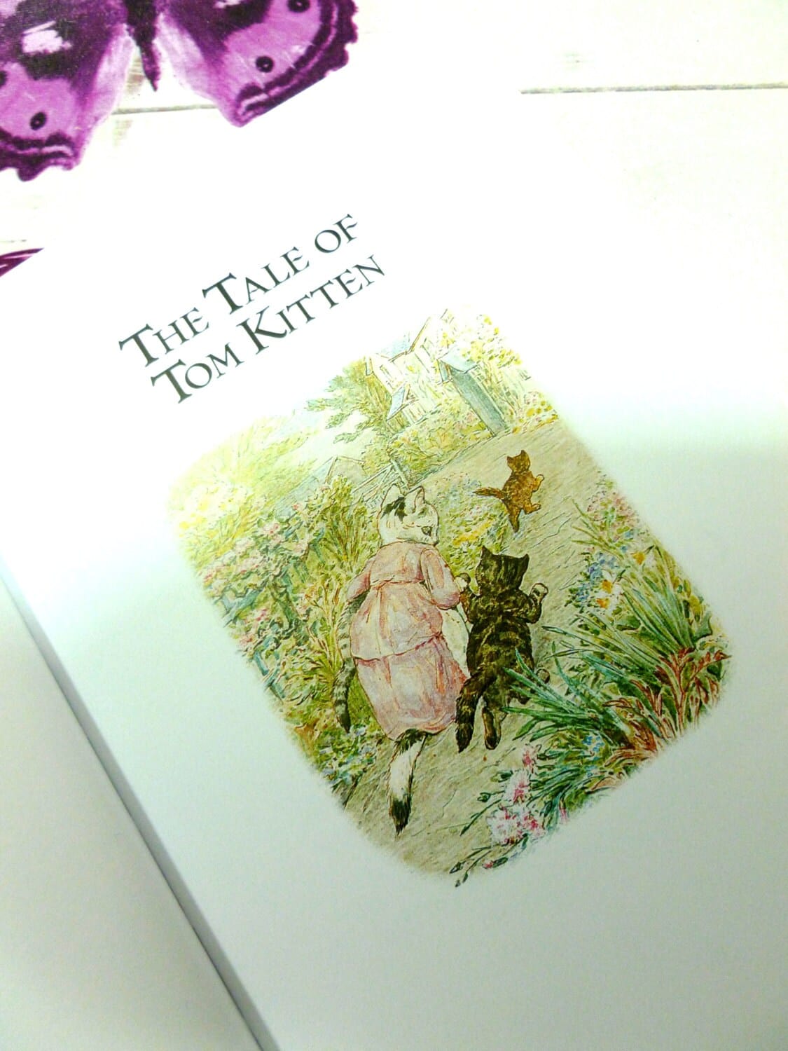 Title page of Beatrix Potter Treasured Tales showing the Tale of Tom Kitten and an illustration of Tom and his mother. 