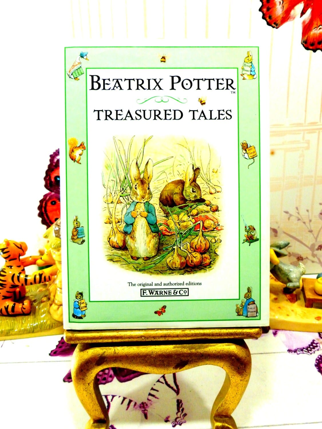 Illustrated front cover Beatrix Potter Treasured Tales showing Peter Rabbit against a green ground showing other Beatrix potter characters. 