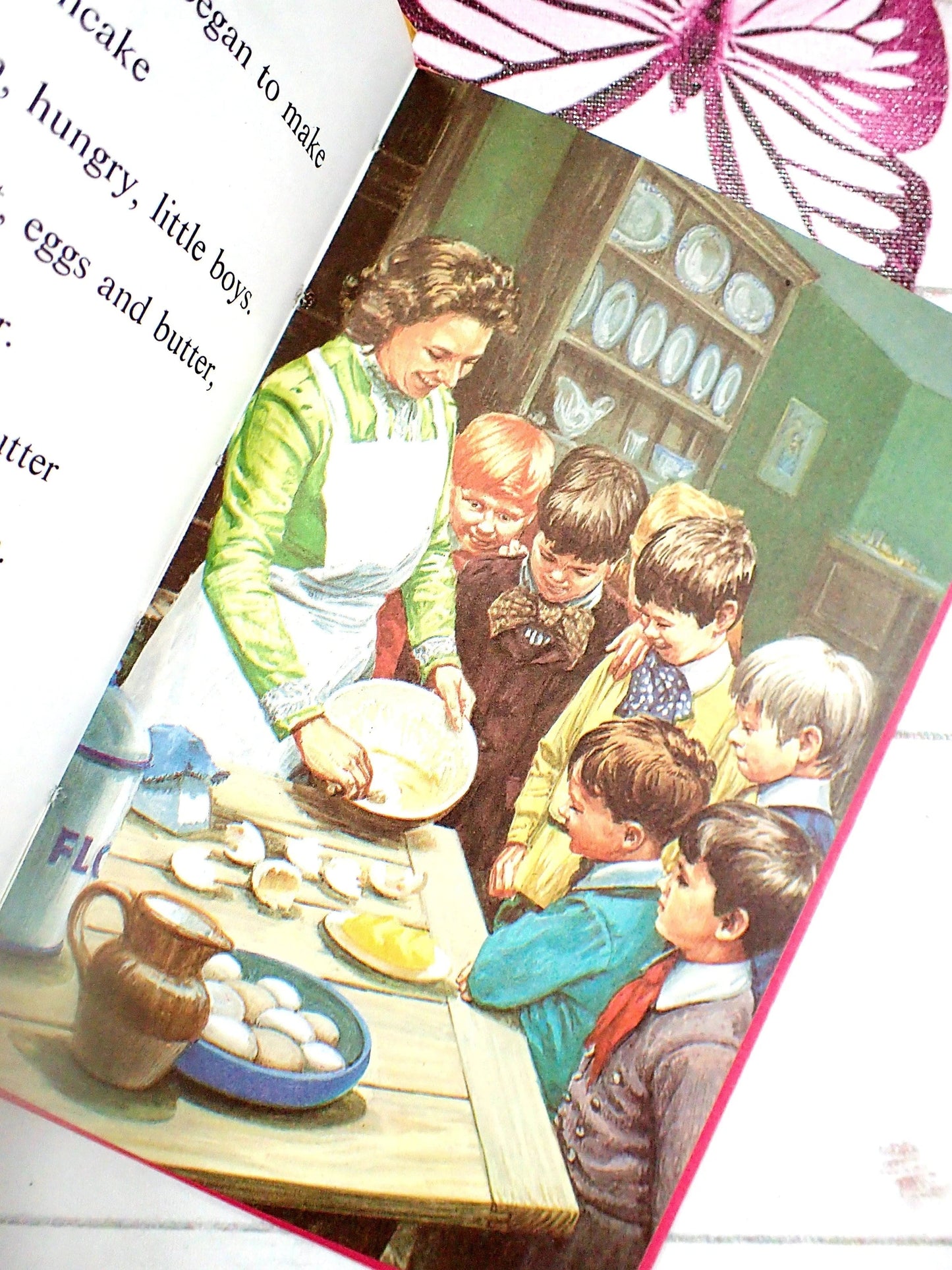 Woman baking pancake with young boys watching.
