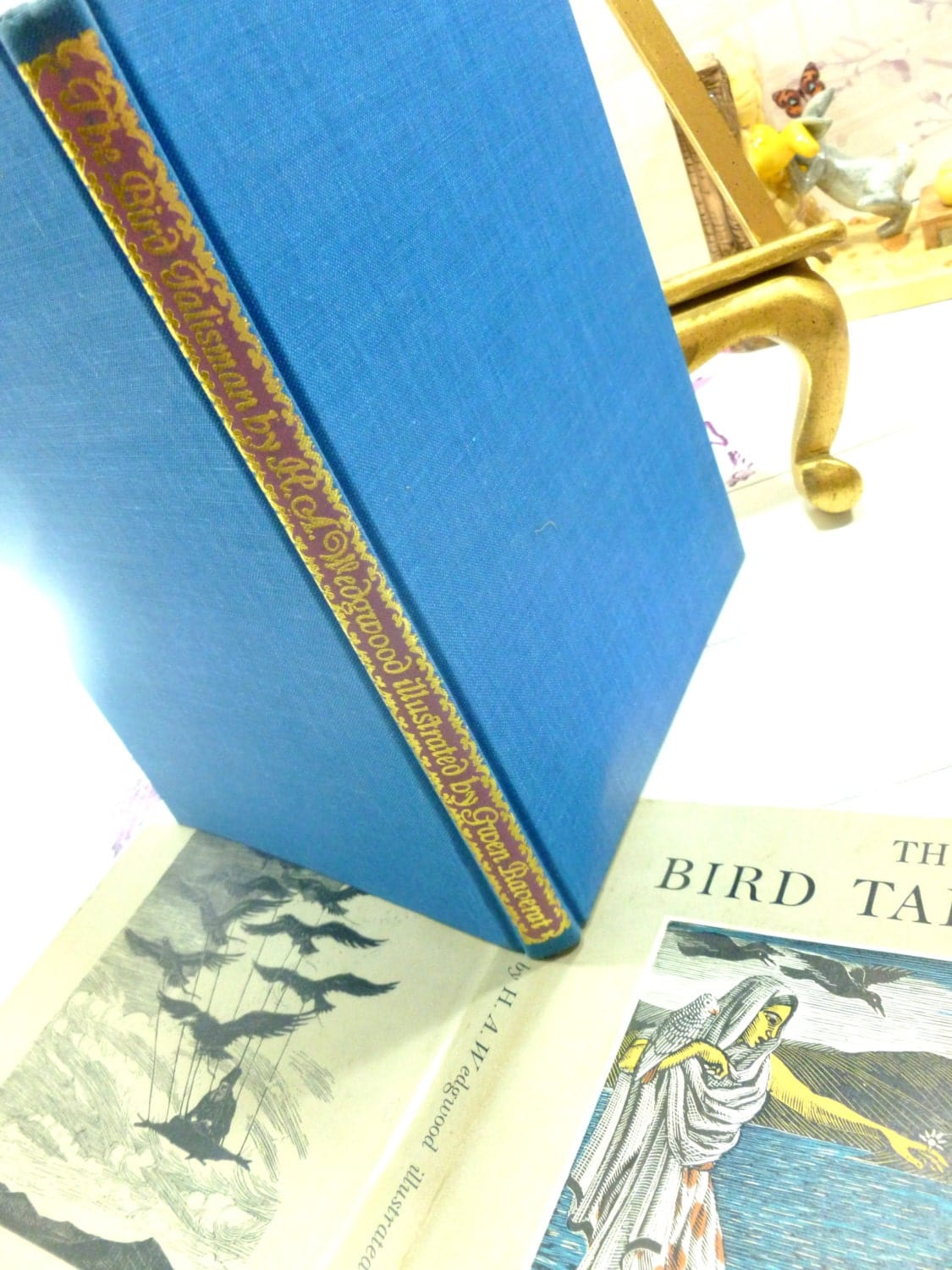 Blue clothbound boards of The Bird Talisman H.A. Wedgwood and Darwin Family Interest Vintage Bird Fairytale Book showing fancy gilt titles to the spine. 