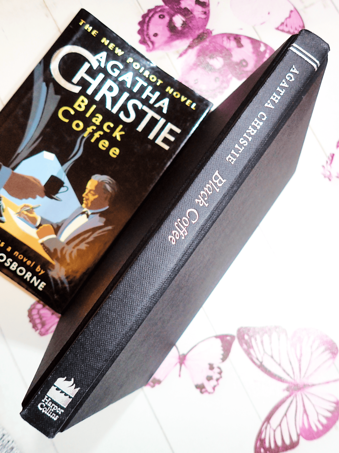 Spine of Agatha Christie Black Coffee Vintage Book Poirot Play Adapted by Charles Osborne with silver titles on black boards with the dust jacket next to it. 