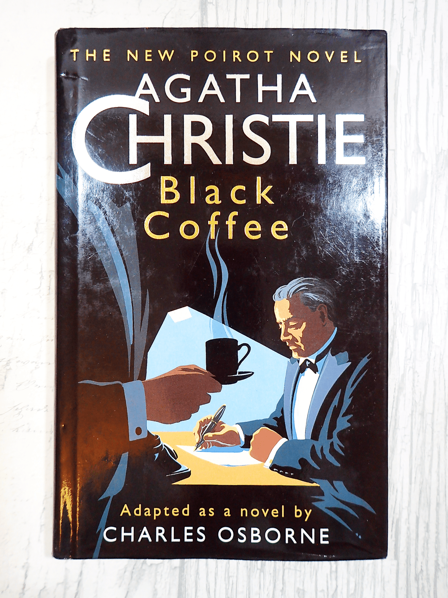 Cover of Agatha Christie Black Coffee Vintage Book Poirot Play Adapted by Charles Osborne with a stylish Art Deco design showing two men in tuxedos and one drinking coffee against a light background. 