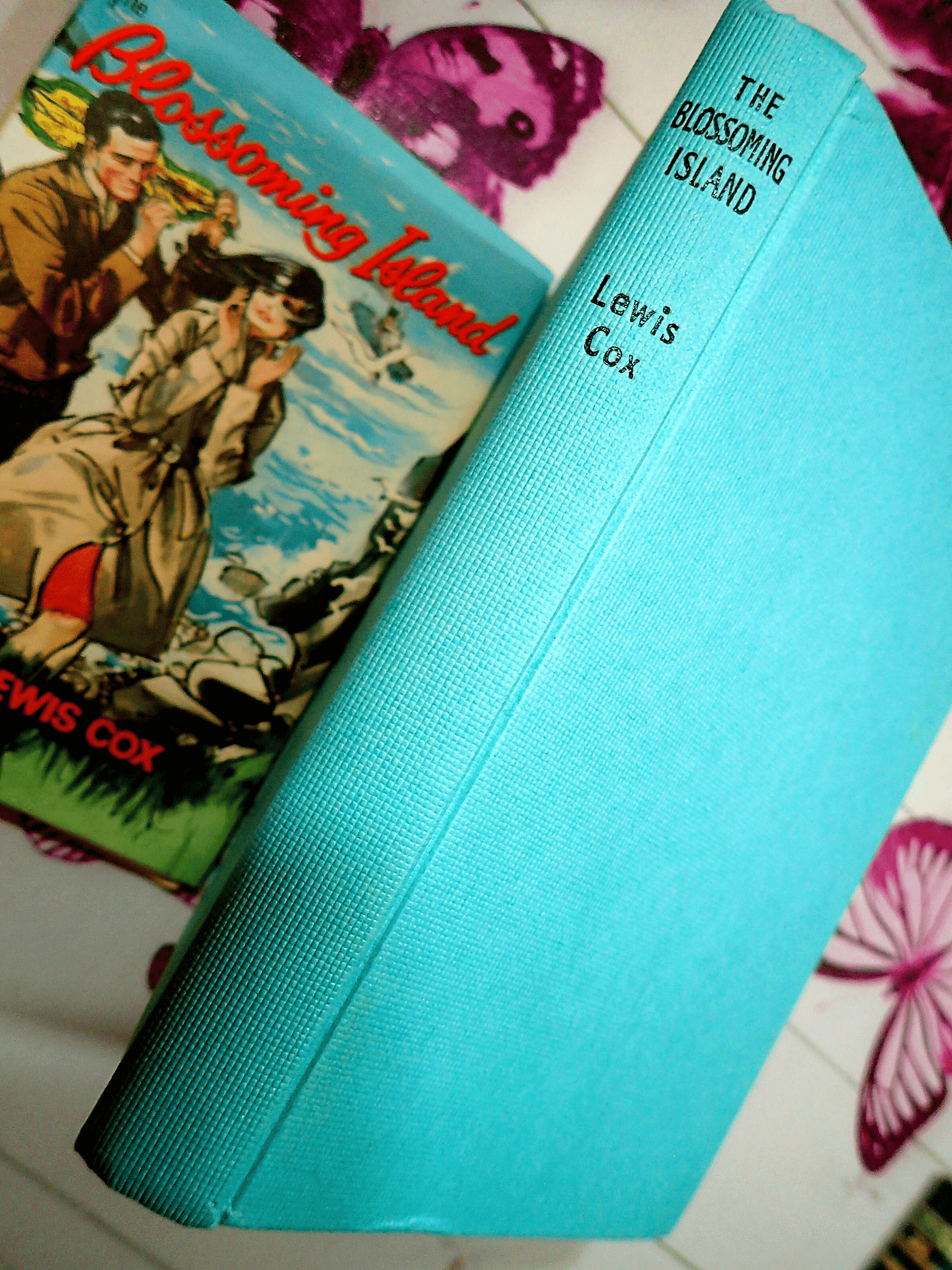 Blue boards of Blossoming Island Lewis Cox Romance Book Club Hardback showing black titles.