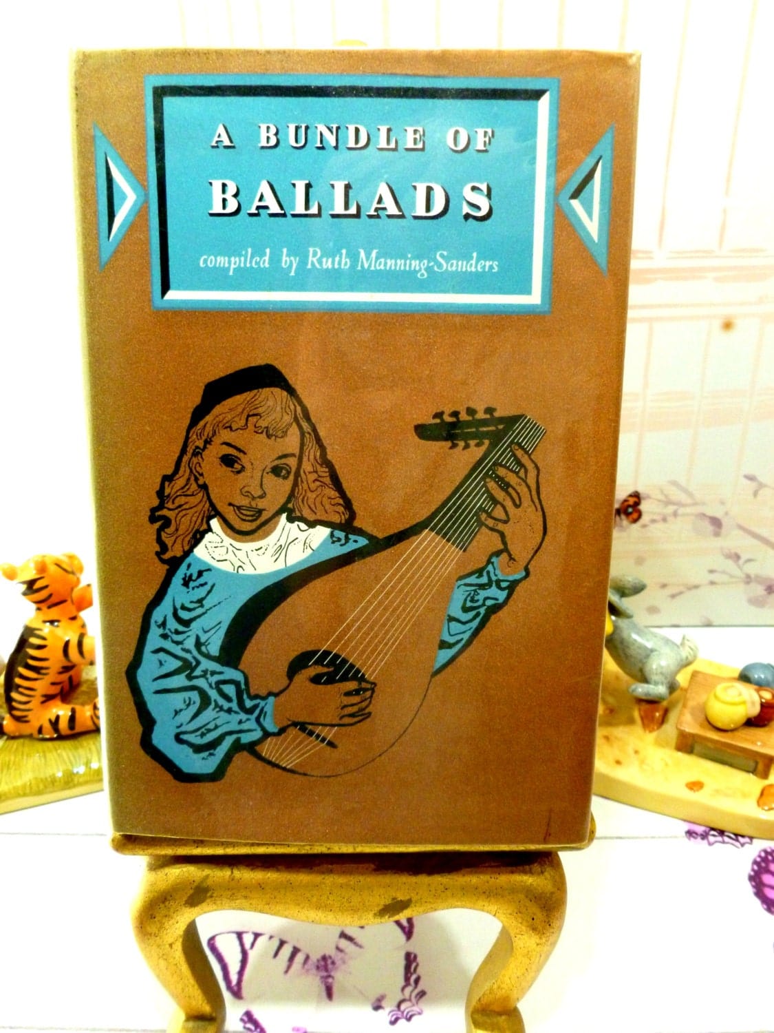 Front cover illustration of vintage book, A Bundle of Ballads showing a medieval dressed man playing a mandolin.