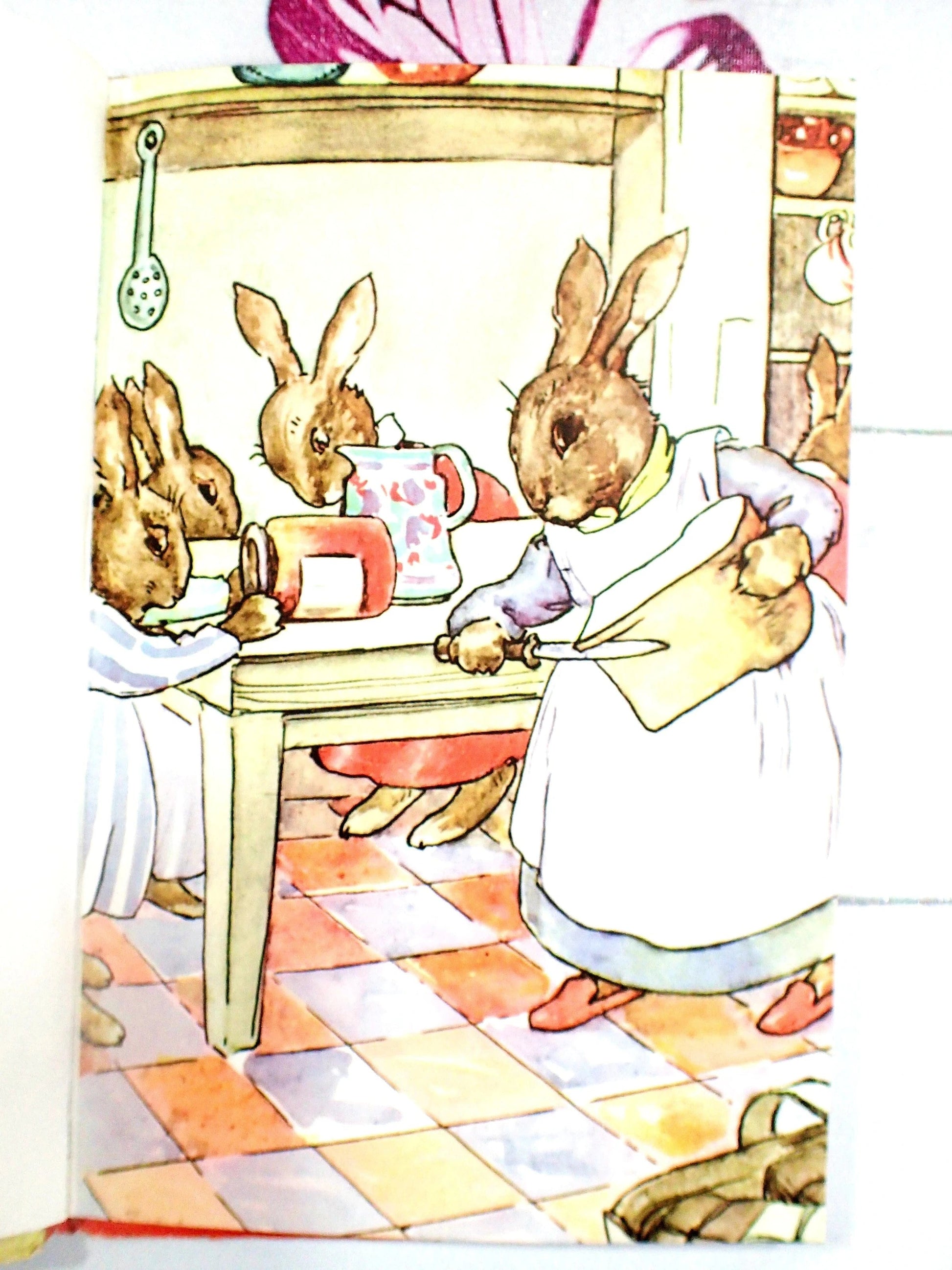 Mrs Bunnikin holding a loaf of bread and bunnies holding a jampot.