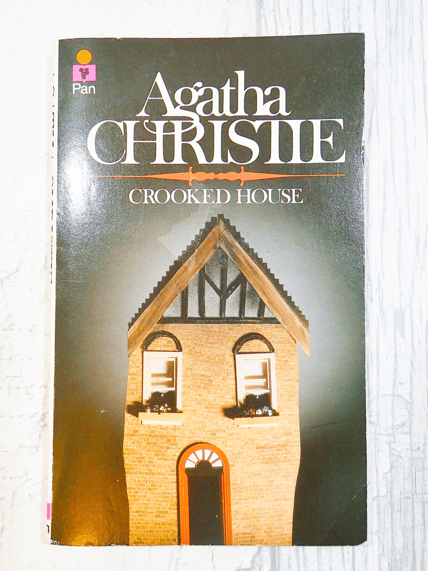 Front cover of Vintage Pan Paperback Agatha Christie 'Crooked House' showing a charming crooked red brick house against a light background. 