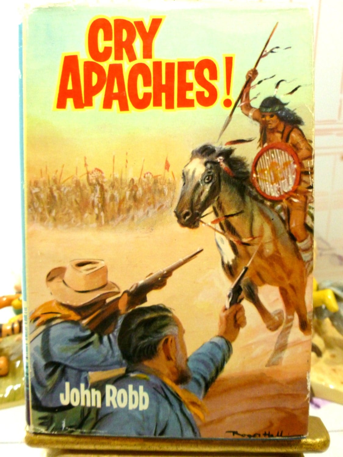 Cover of Cry Apache Catsfoot Cowboy Stories 1960s Vintage Hardback children's book showing cowboy fighting an Indian with guns. 
