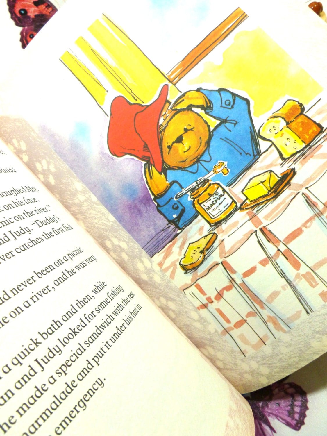 Page of the Giant Paddington Story Book by Michael Bond Paddington Bear First Ed. 1989 showing Paddington sat at a table eating a marmalade sandwich. 