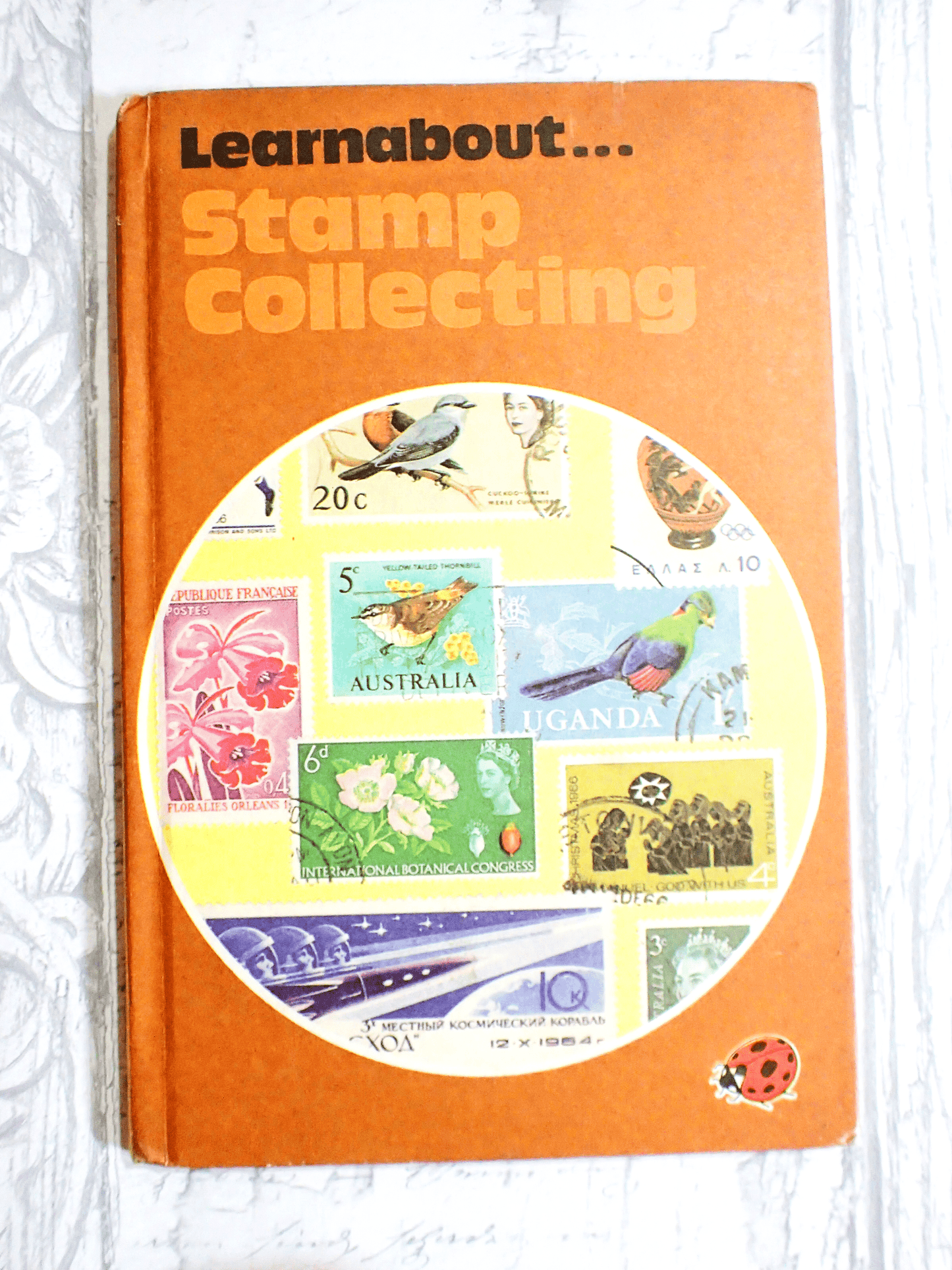 Ladybird Book Learnabout Stamp Collection Orange Cover against pale grey background. 