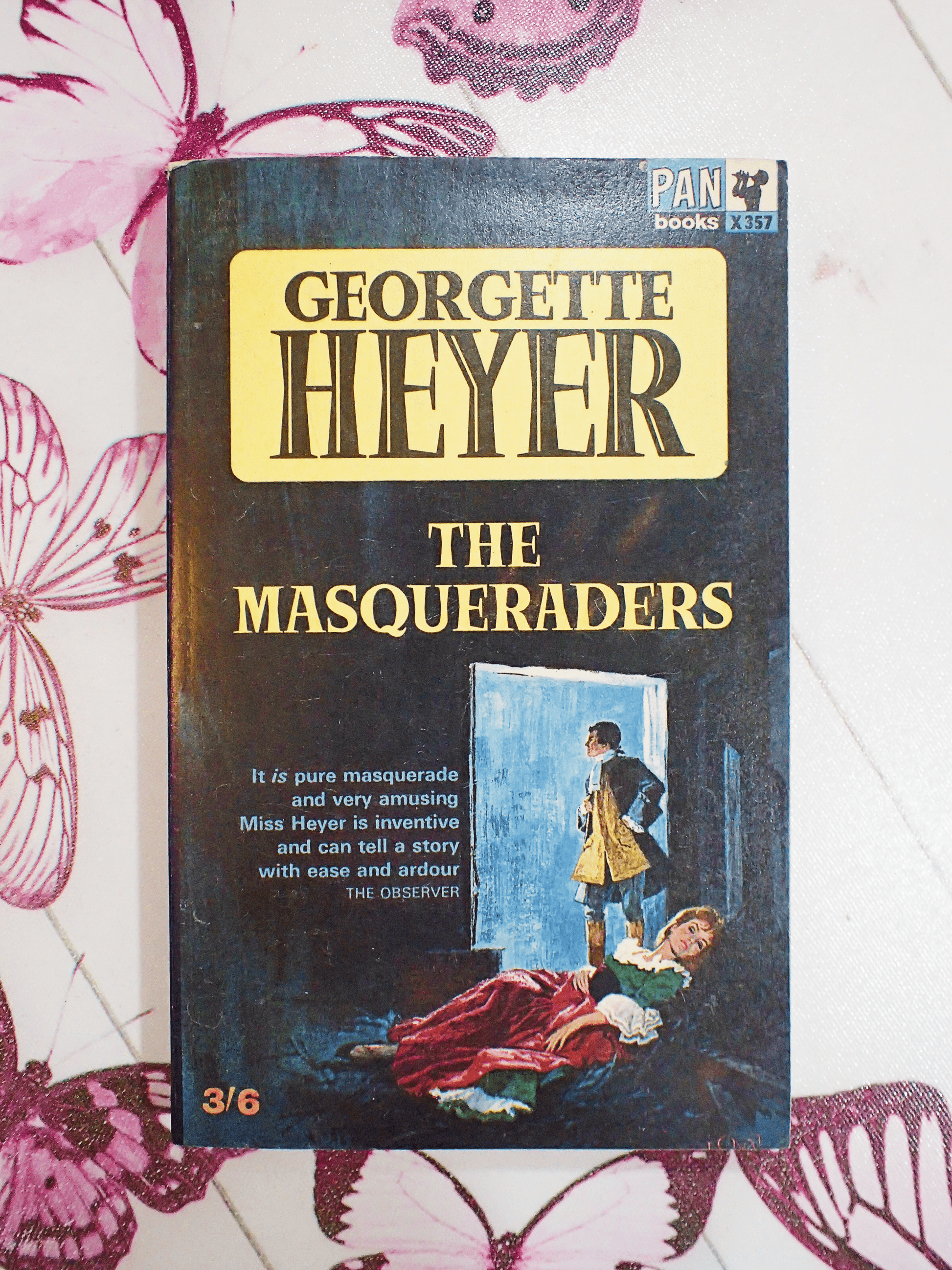 Front cover of vintage Pan paperback book, 'The Masqueraders', by Georgette Heyer showing a man and woman in Georgian costume and the book titles in yellow and black. 