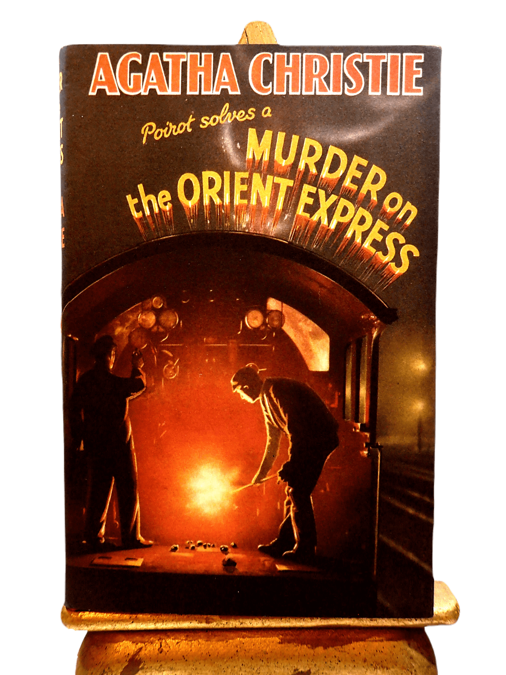 Front cover of Murder on the Orient Express Agatha Christie Facsimile Vintage Book showing a man shovelling coal into a train furnace. 