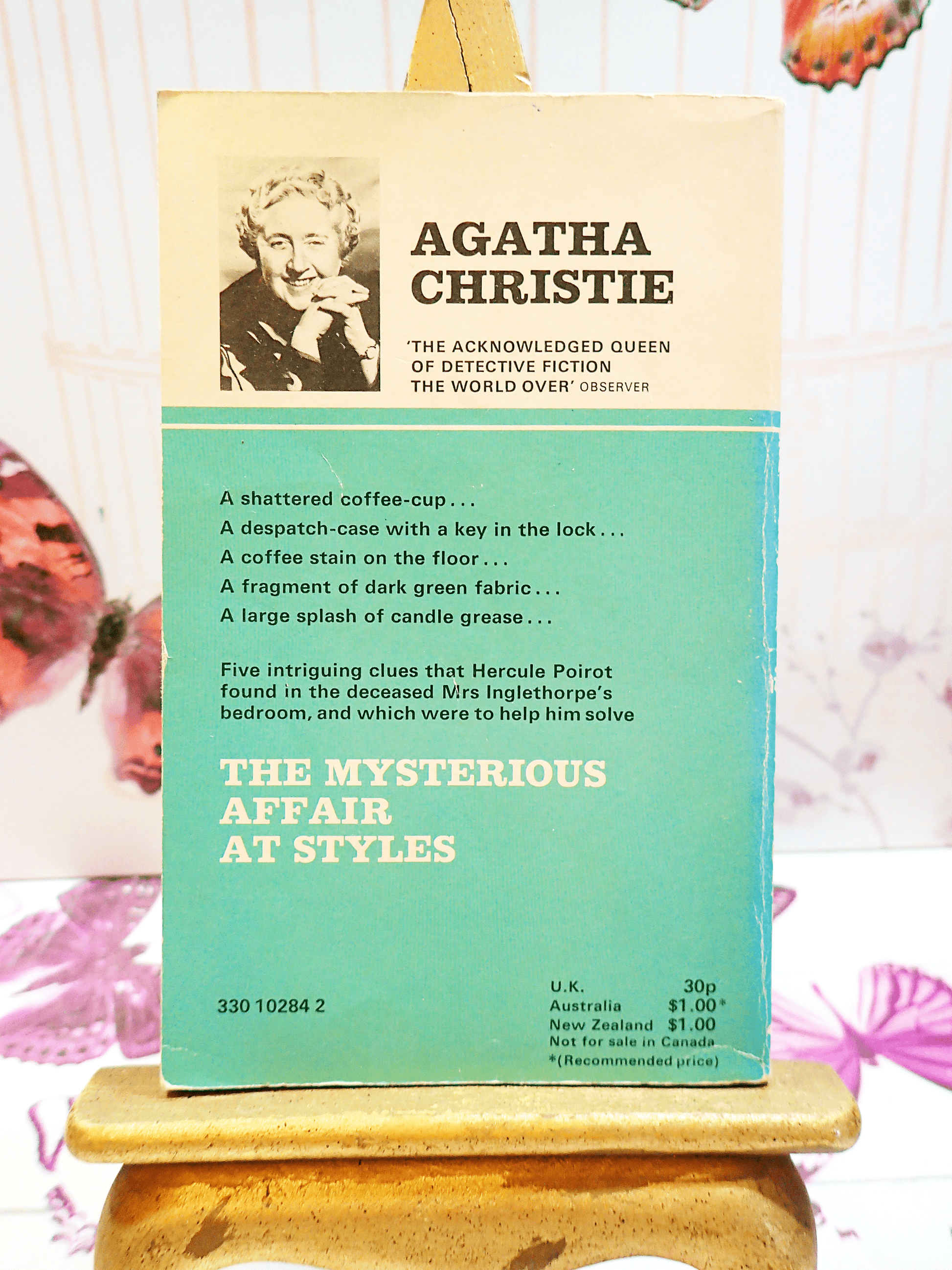 Back cover of Agatha Christie's book The Mysterious Affair at Style, Vintage Pan Paperback, showing a black and white photo of Agatha Christie with text blurb: "A shattered coffee cup..."