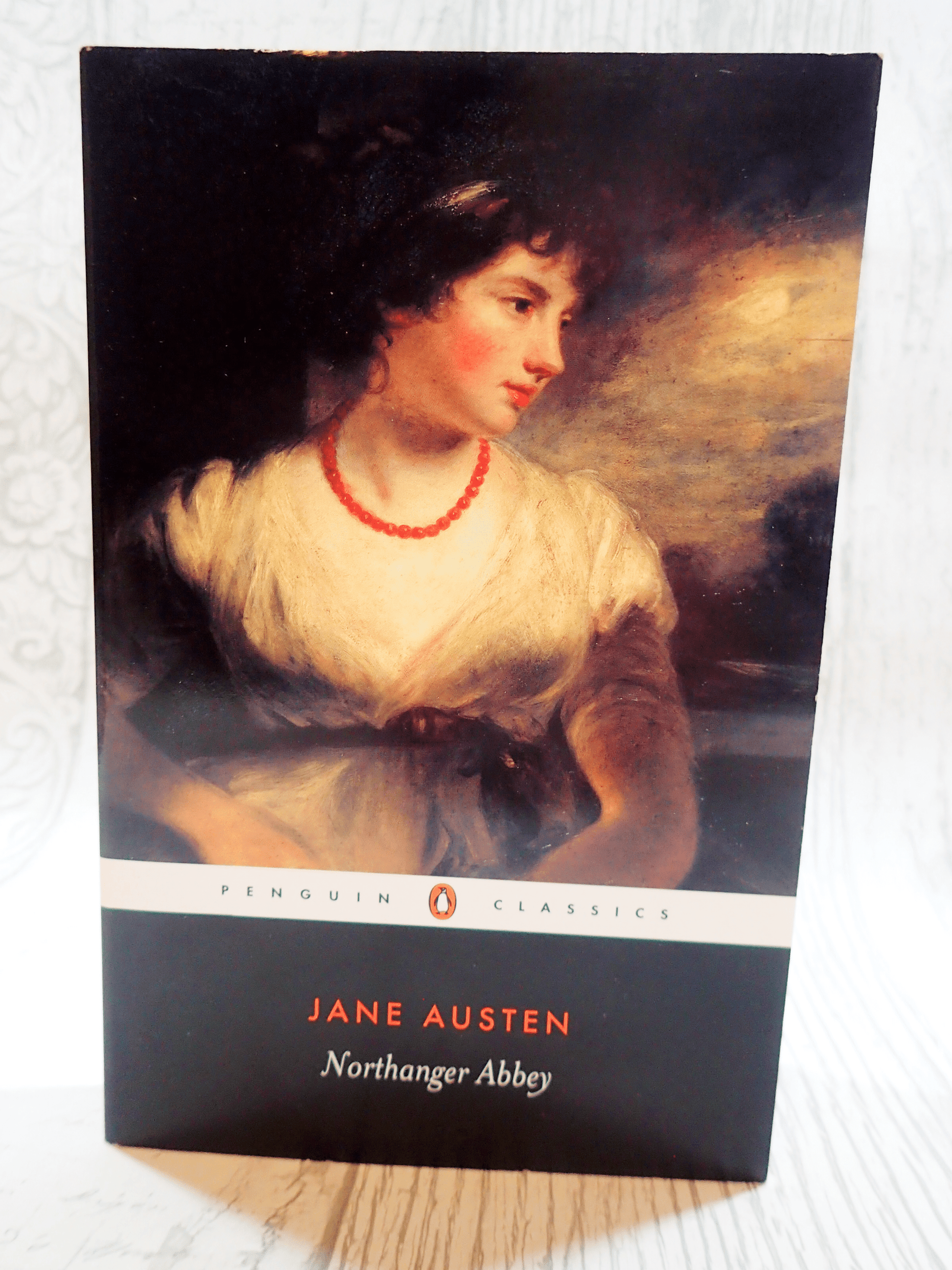Front cover of Northanger Abbey Jane Austen Puffin Paperback showing a Regency lady wearing a coral necklace against a light background.